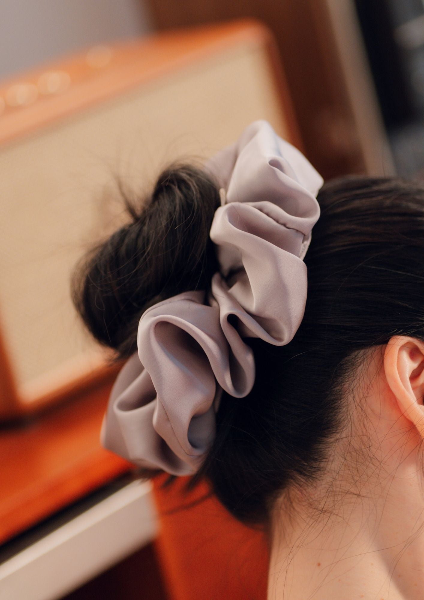 Woman wearing Medium Size the PEKGEE Signature Satin Scrunchie in hair bun.